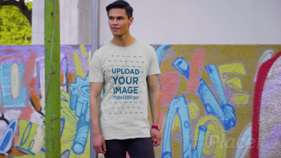 T-Shirt Video of a Young Man Walking by a Wall with Street Art 3113v