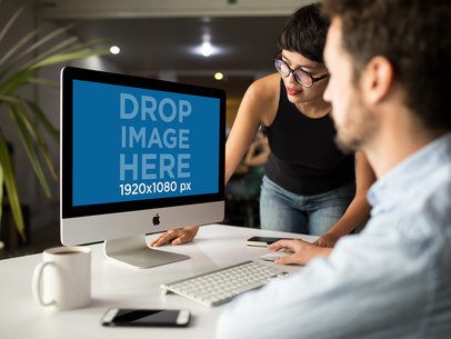 Girl Showing Something in iMac Mockup to Coworker a16266