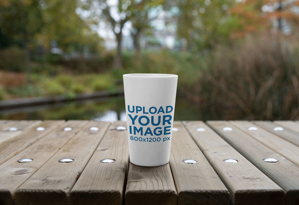 Placeit - Mockup of a Reusable Cup on a Wooden Surface
