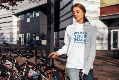Mockup of a Woman with a Hoodie Posing by a Bike Station 