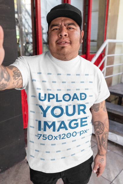 T-Shirt Mockup of a Man with Tattooed Arms Taking a Selfie 