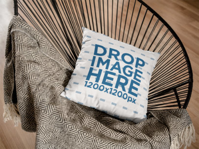 Mockup of a Pillow Lying on a Black Acapulco Chair in a Living Room
