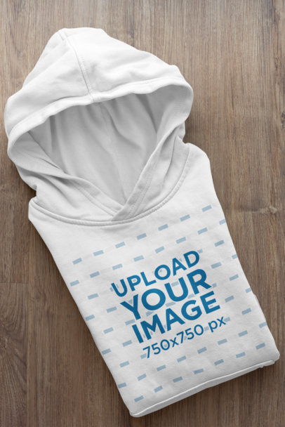 Mockup of a Folded Hoodie Placed on a Wooden Surface 33875a