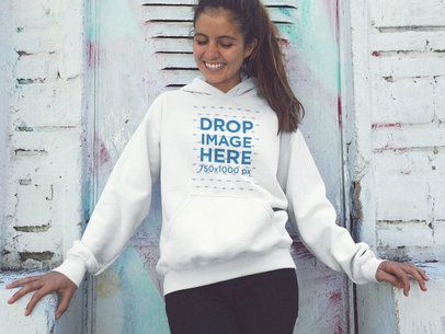 Smiling Young Girl Wearing a Pullover Hoodie Mockup Against a White Wall a12848